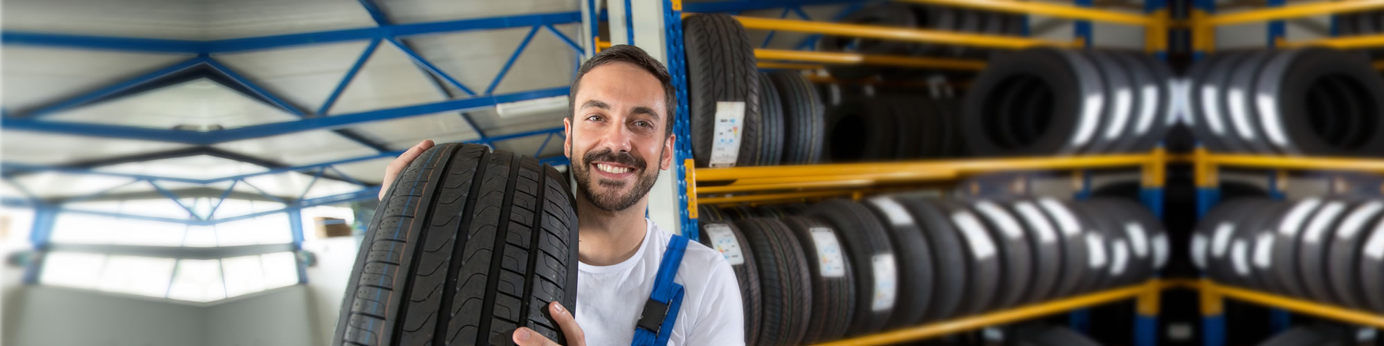 A man holding two tires in his hands.